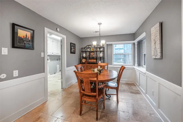 a view of a dining room with furniture and chandelier
