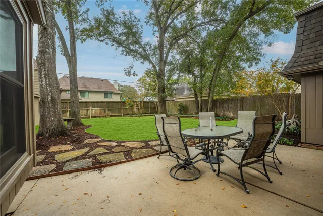a view of a chair and table in backyard of the house