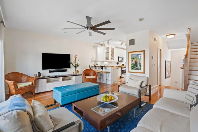 a living room with furniture kitchen view and a flat screen tv