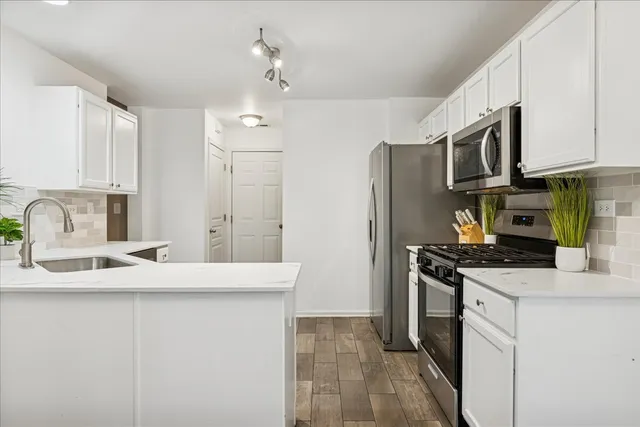 a kitchen with stainless steel appliances a sink stove refrigerator and cabinets