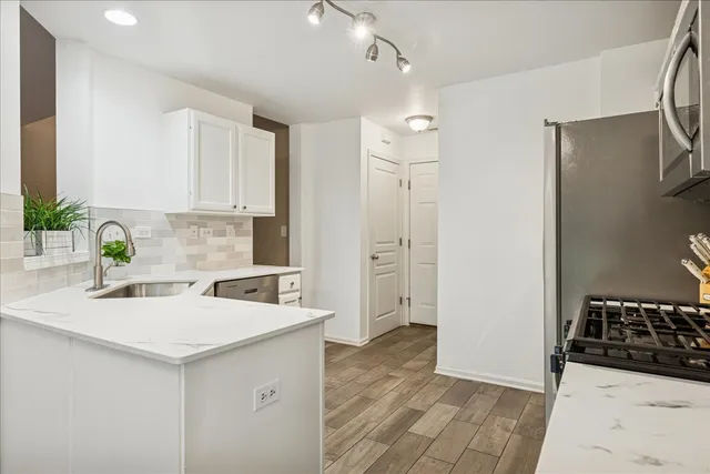 a kitchen that has a sink a refrigerator and cabinets