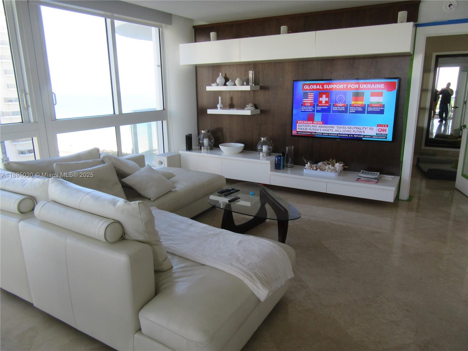 6365 Collins Avenue, Unit 1008 Miami Beach, FL 33141 - Photo 11 of 49 a living room with furniture and a flat screen tv