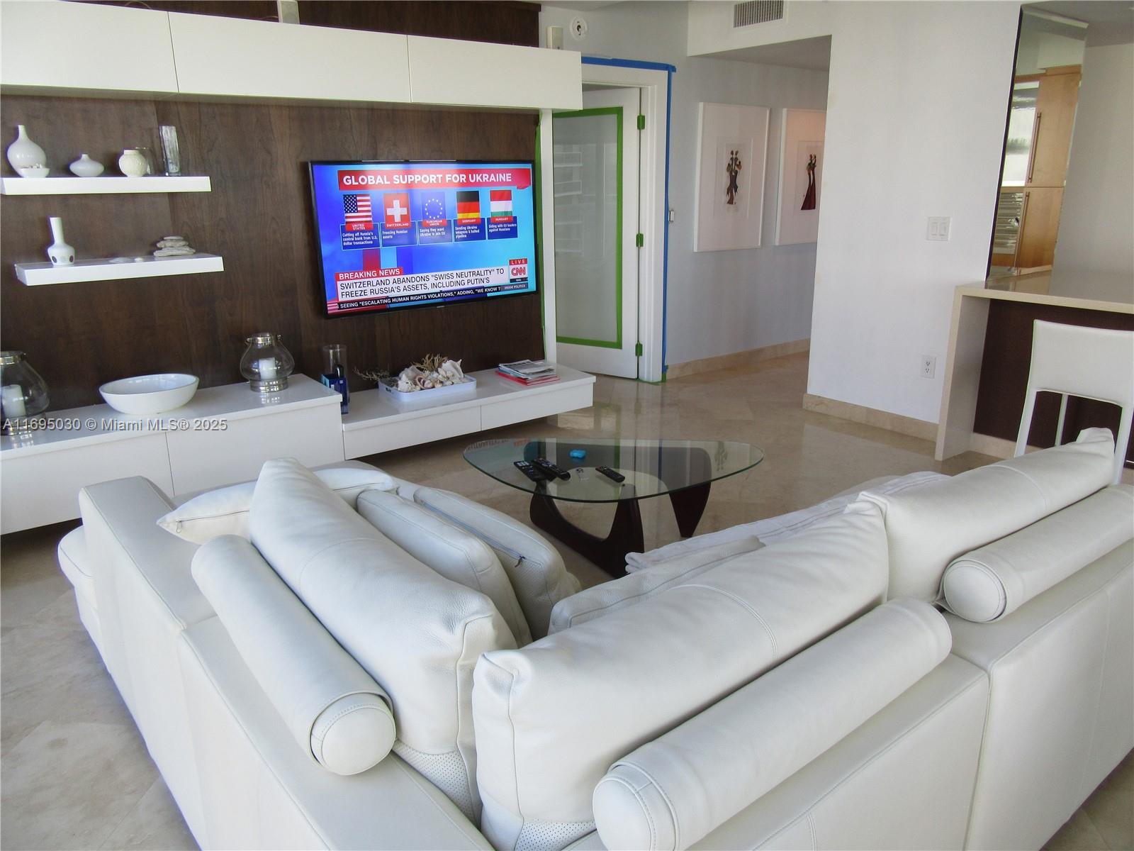 6365 Collins Avenue, Unit 1008 Miami Beach, FL 33141 - Photo 12 of 49 a living room with furniture and a flat screen tv