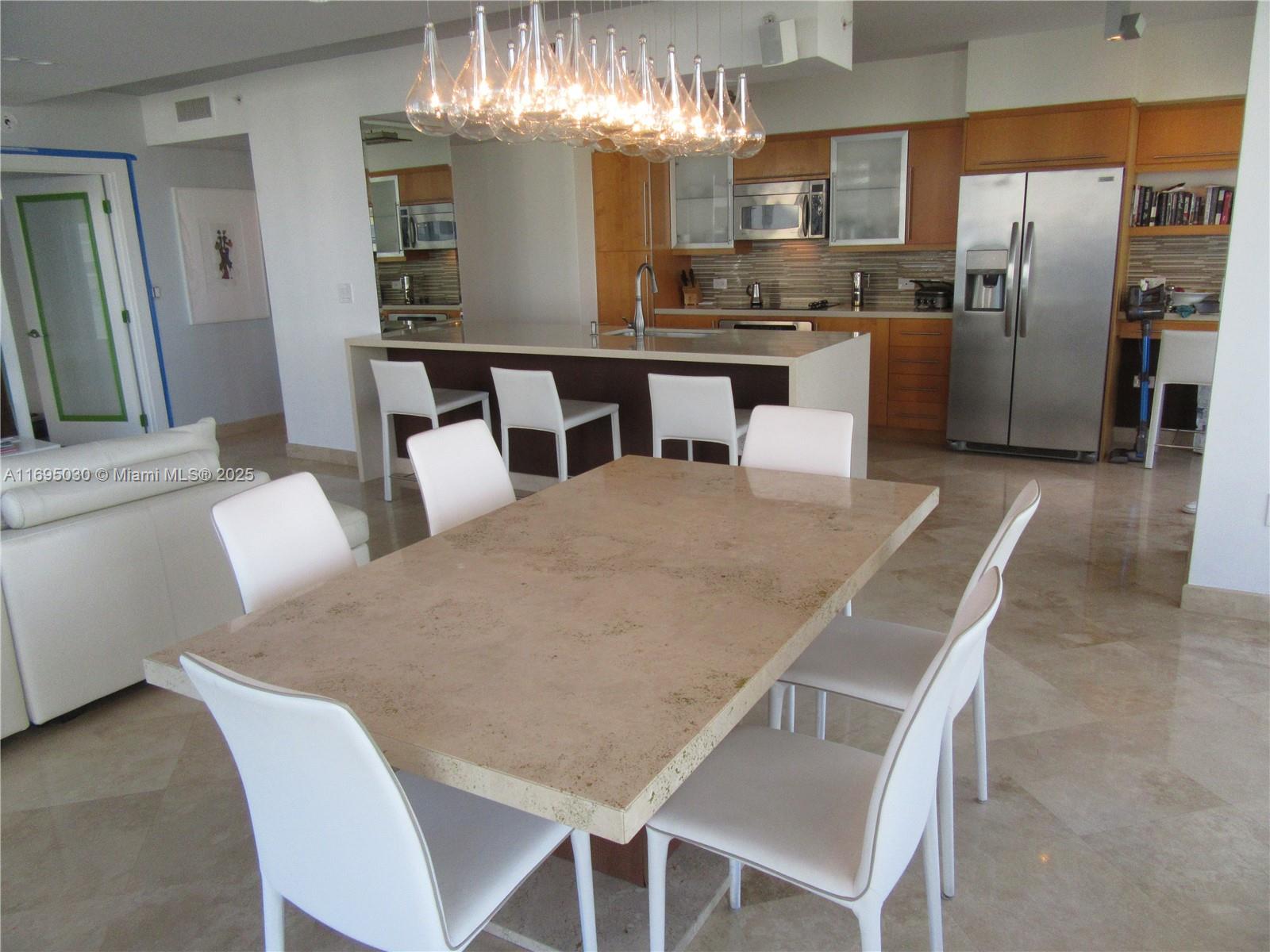 6365 Collins Avenue, Unit 1008 Miami Beach, FL 33141 - Photo 15 of 49 a large kitchen with a table and chairs