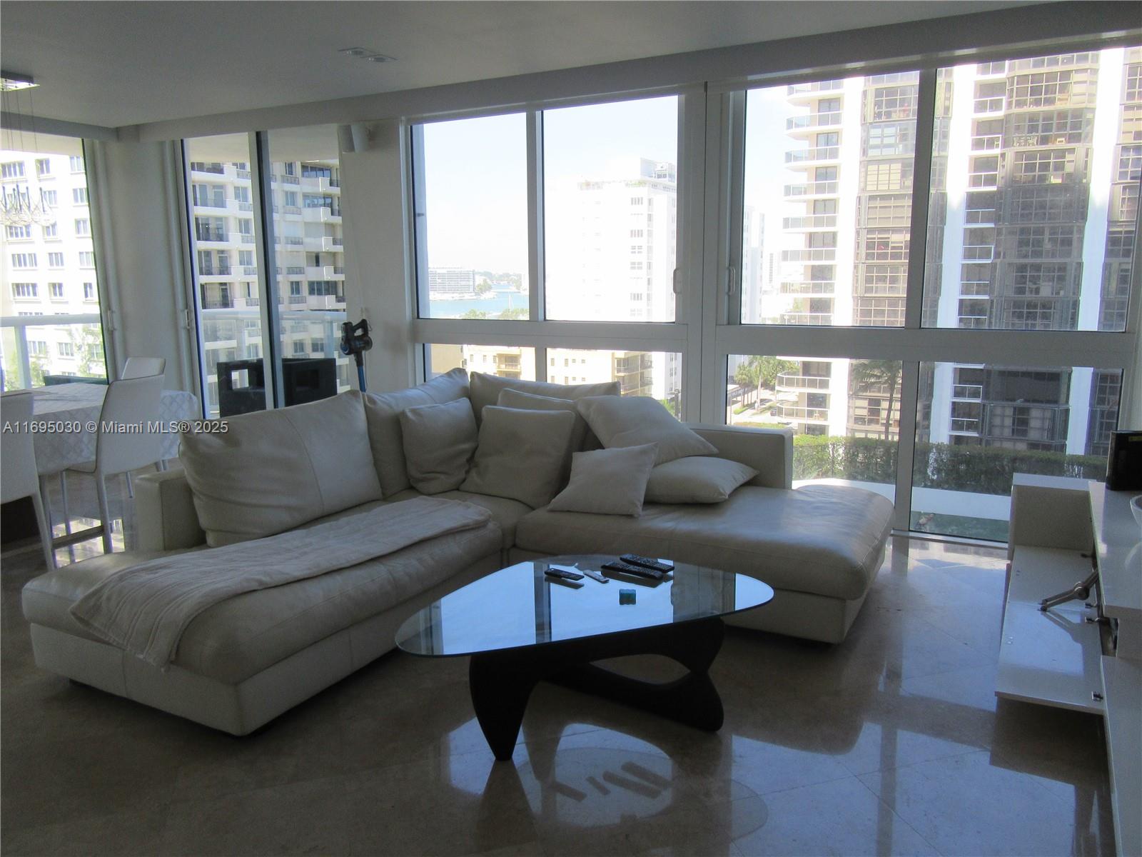 6365 Collins Avenue, Unit 1008 Miami Beach, FL 33141 - Photo 10 of 49 a living room with furniture and a large window