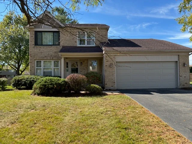 a view of a house with a large window and potted plants