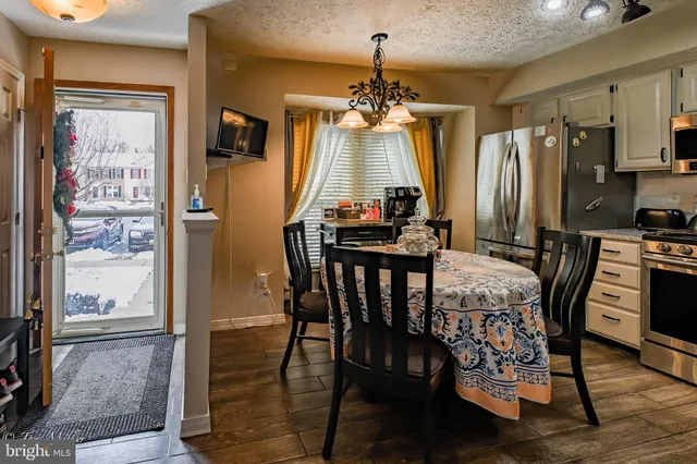 a view of a dining room with furniture a chandelier and wooden floor