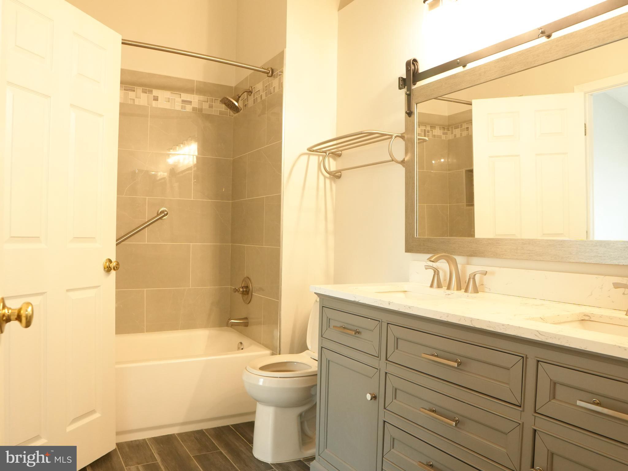 21 Cedarcone Court Nottingham, MD 21236 - Photo 12 of 38 a bathroom with a double vanity sink toilet mirror and bathtub