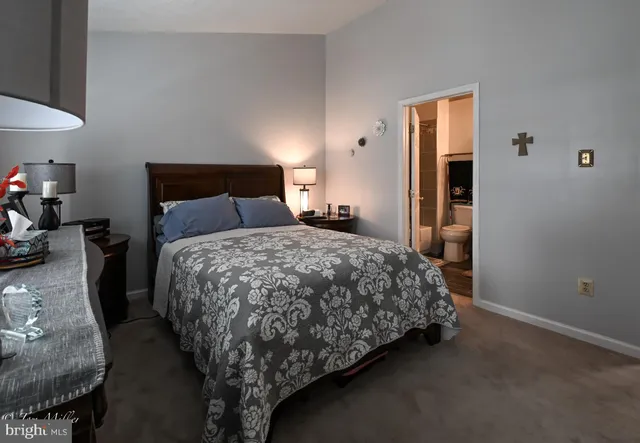 a bed sitting in a bedroom next to a window and a lamp