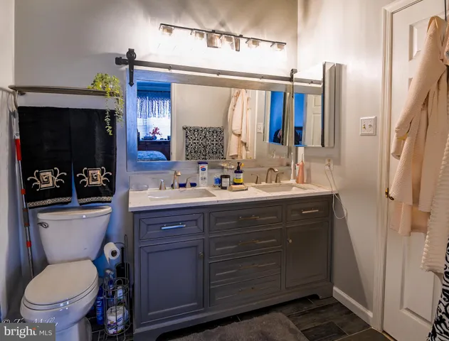 a bathroom with a toilet a sink and a mirror