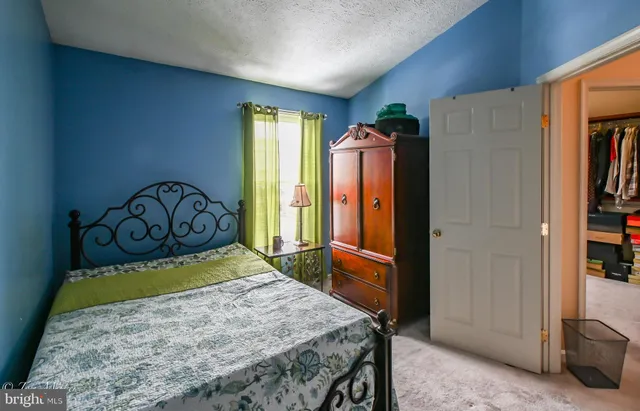a bedroom with a bed a large mirror and dresser
