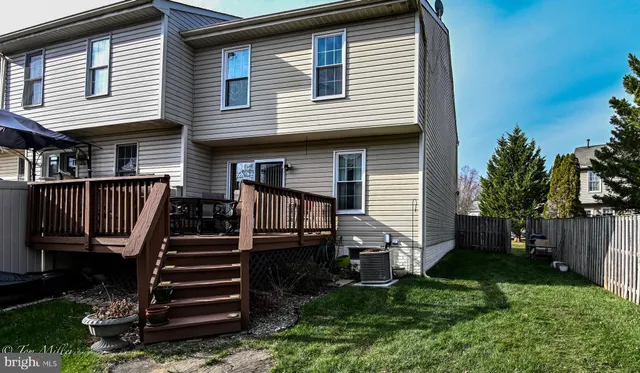 a view of a house with backyard and wooden deck