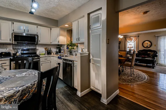 a kitchen with a table chairs refrigerator and cabinets