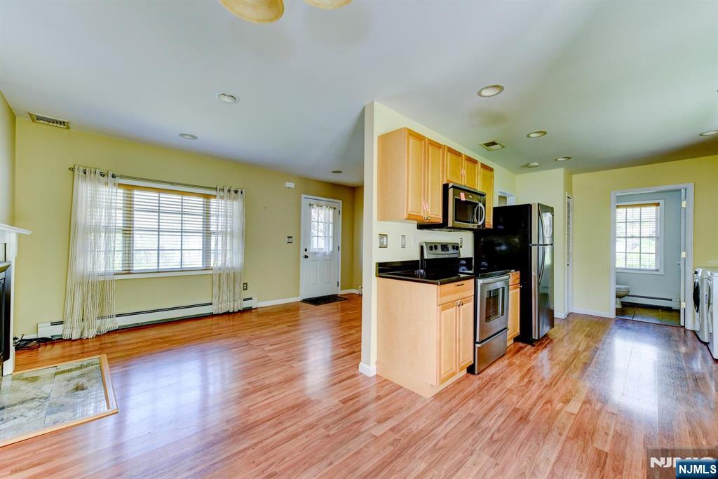 64 Hilltop Trail Sparta, NJ 07871 - Photo 14 of 40 a kitchen with stainless steel appliances kitchen island wooden floors and white cabinets