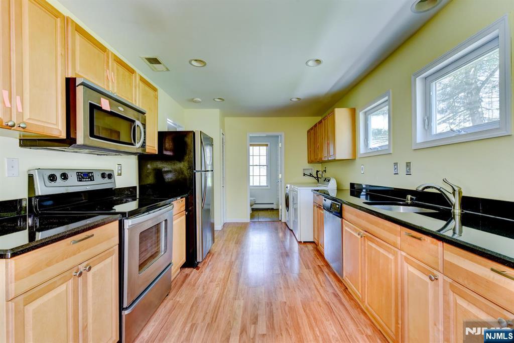 64 Hilltop Trail Sparta, NJ 07871 - Photo 15 of 40 a kitchen with stainless steel appliances wooden cabinets a stove a sink and a microwave