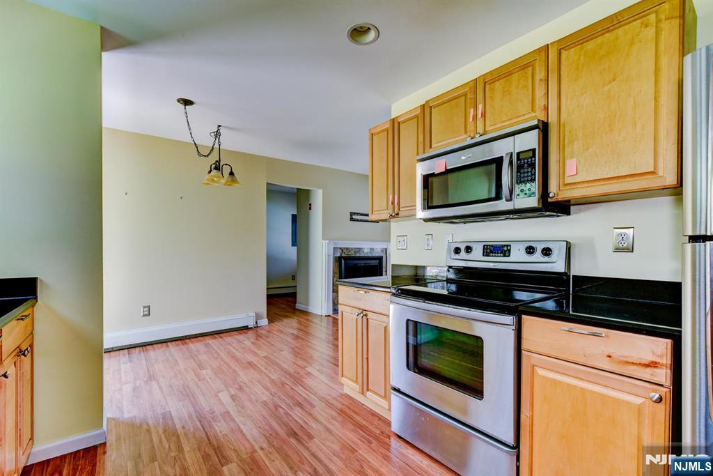 64 Hilltop Trail Sparta, NJ 07871 - Photo 22 of 40 a kitchen with granite countertop wooden floors and stainless steel appliances