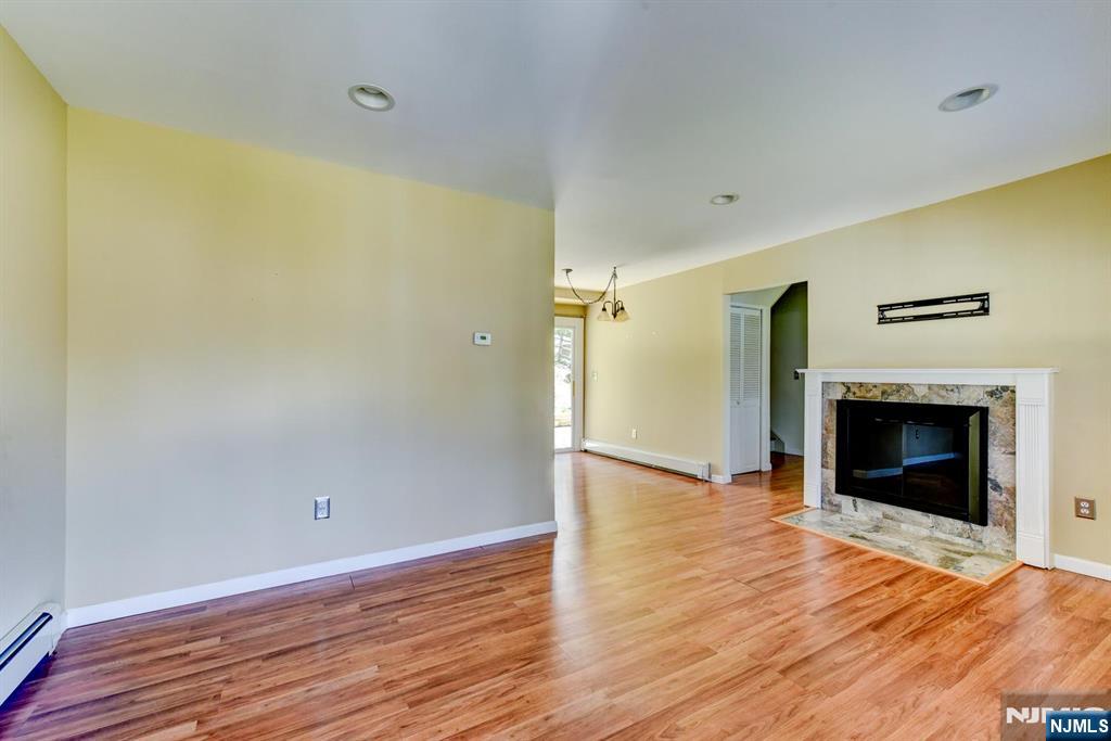 64 Hilltop Trail Sparta, NJ 07871 - Photo 7 of 40 a view of an empty room with wooden floor fireplace and a window