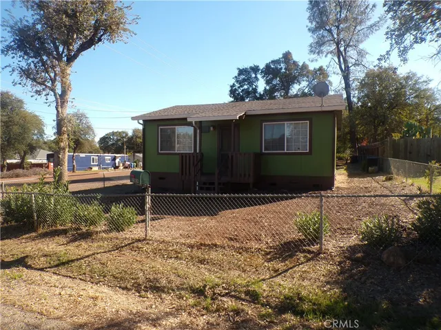 a front view of a house with a yard covered with snow