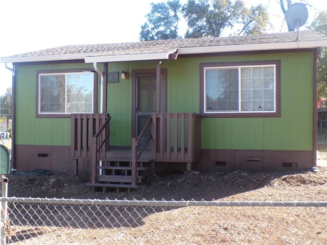 a view of a house with a yard and wooden fence