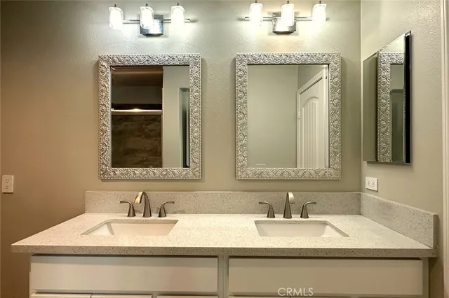 a bathroom with double vanity sinks and a mirror