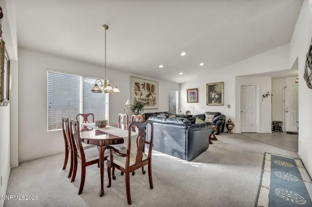 a view of a dining room and livingroom with furniture wooden floor a chandelier