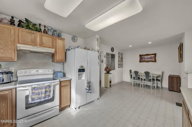 a living room with furniture a kitchen view and a refrigerator
