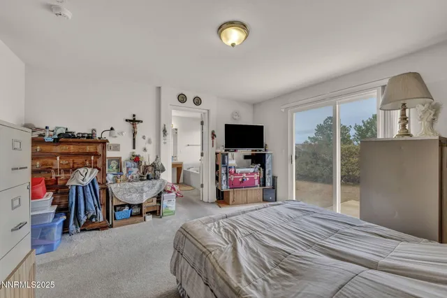 a bedroom with bed a flat tv and a desk