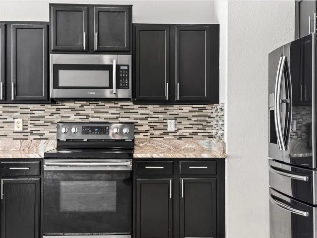 a kitchen with granite countertop a refrigerator and a sink