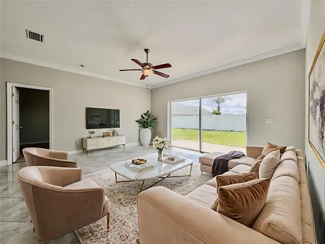 an empty room with windows and chandelier fan