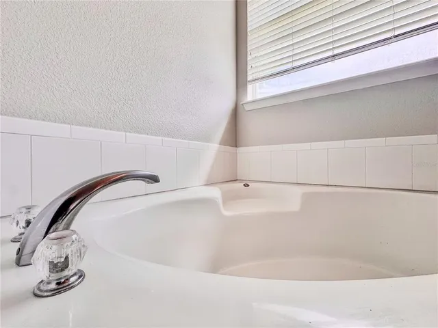 a spacious bedroom with a bed and a large window