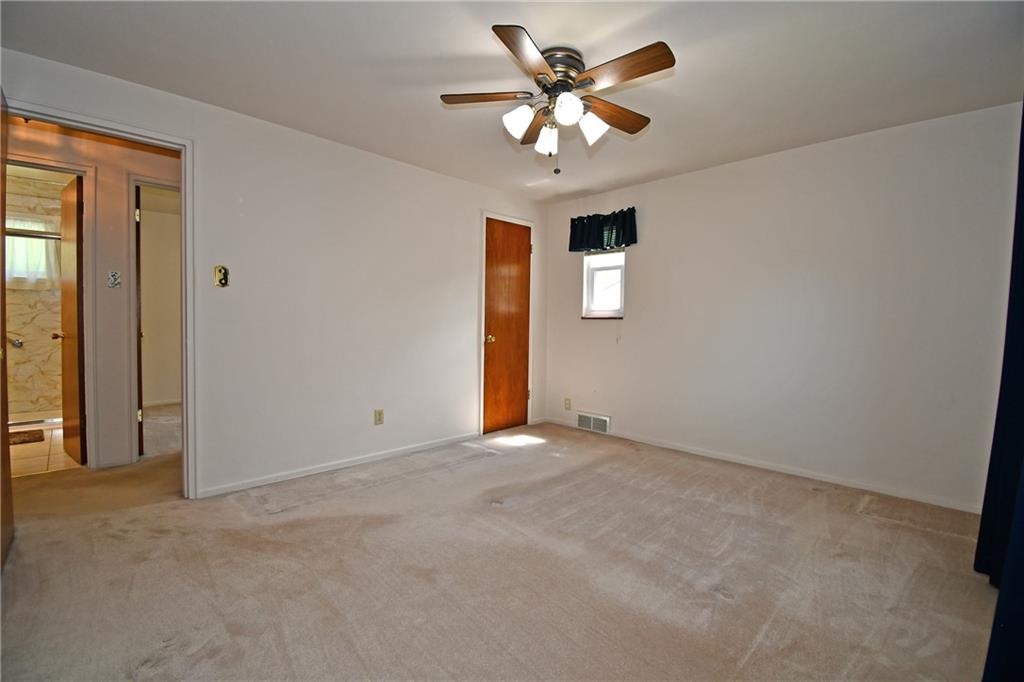 801 Highview Road Pittsburgh, PA 15234 - Photo 16 of 30 an empty room with a chandelier fan and windows