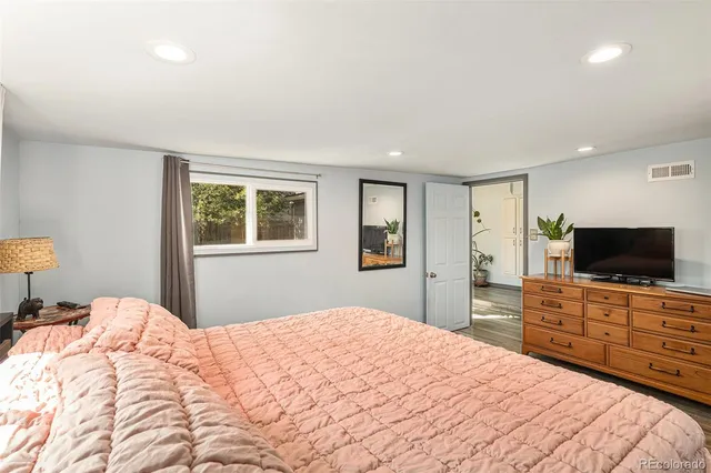 a bedroom with a bed and a flat screen tv on dresser