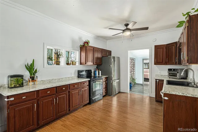 a kitchen with stainless steel appliances granite countertop a refrigerator a stove a sink dishwasher and a oven with wooden floor