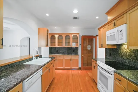 a large kitchen with stainless steel appliances granite countertop a sink and a stove
