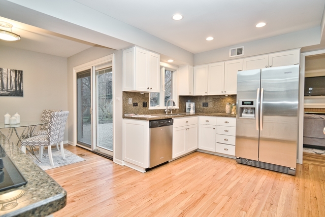 4052 Michelline Lane Northbrook, IL 60062 - Photo 13 of 44 a kitchen with white cabinets and stainless steel appliances