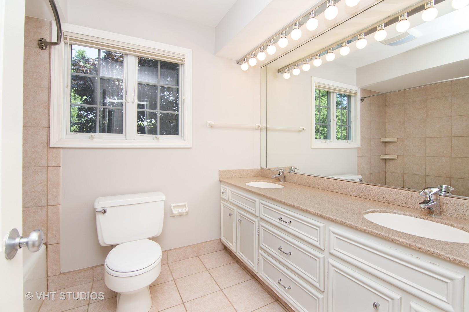 4052 Michelline Lane Northbrook, IL 60062 - Photo 35 of 44 a bathroom with a granite countertop toilet a sink a mirror and a window