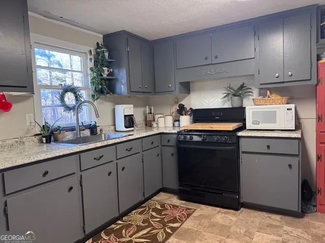 a kitchen with granite countertop cabinets a sink and appliances