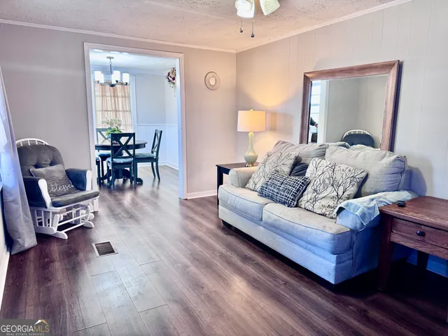 a living room with furniture and wooden floor