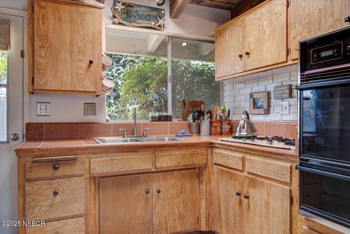 321 North Sixth Street Lompoc, CA 93436 - Photo 11 of 30 a kitchen with appliances cabinets and a sink