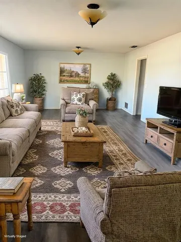 a living room with furniture and wooden floor