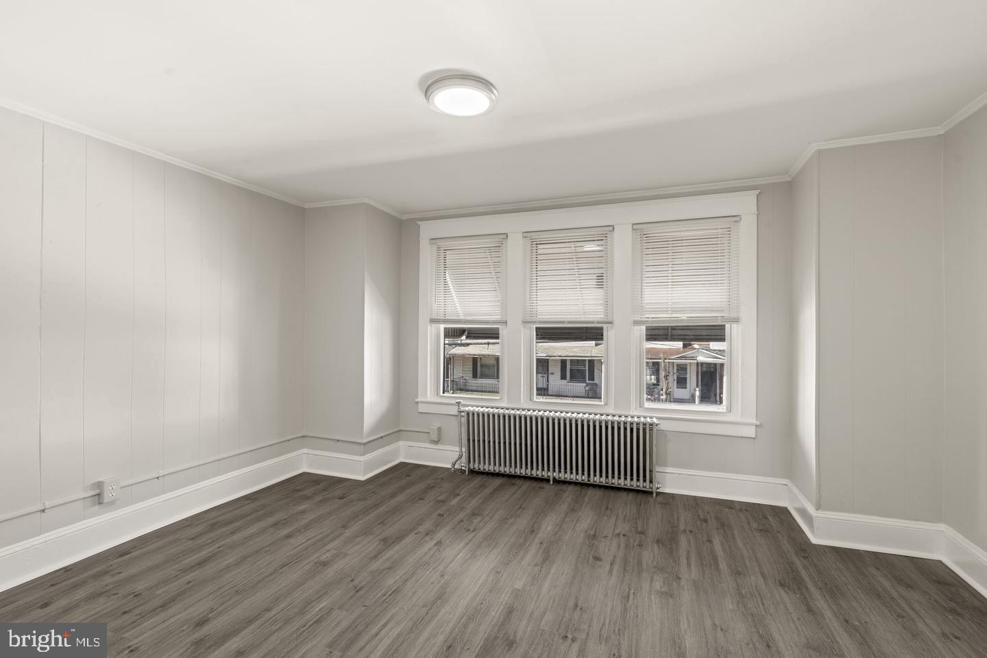 1213 West 9th Street Chester, PA 19013 - Photo 3 of 6 an empty room with wooden floor and windows