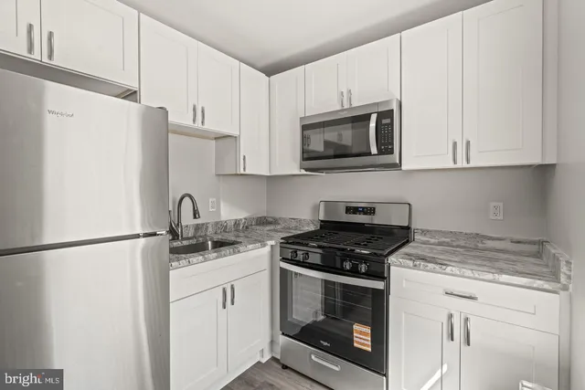 a kitchen with appliances a sink and cabinets