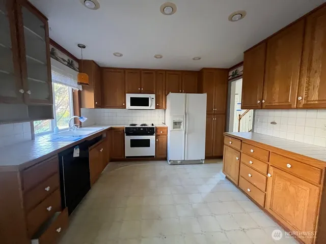 a kitchen with stainless steel appliances a refrigerator sink and cabinets