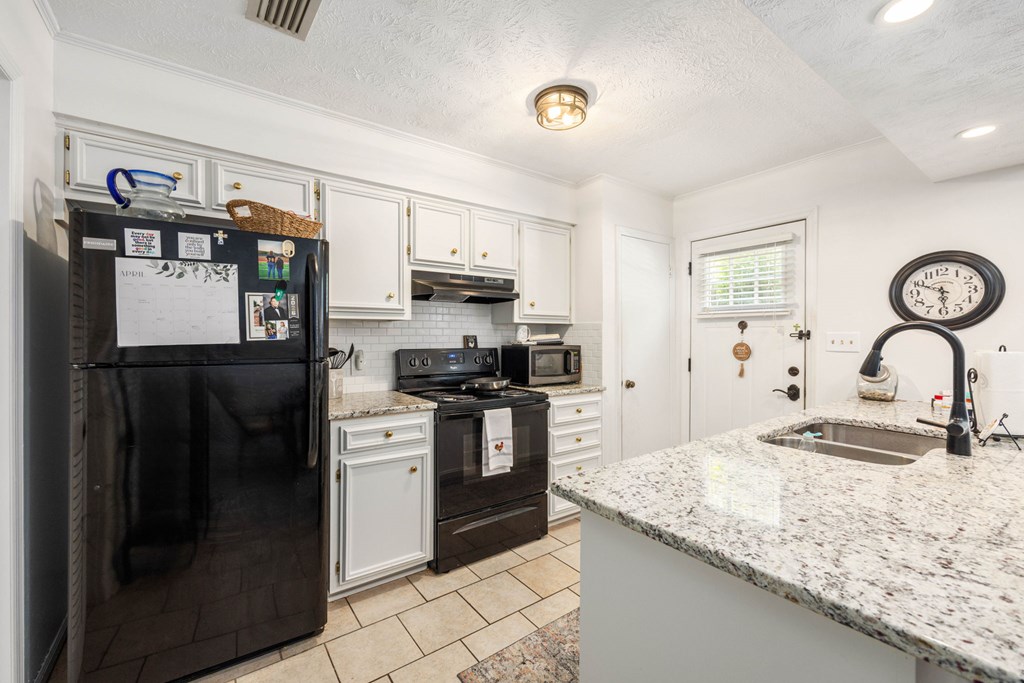 6101 River Road, Unit 15 Columbus, GA 31904 - Photo 9 of 22 a kitchen with granite countertop stainless steel appliances and a refrigerator