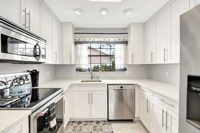 a kitchen with white cabinets and stainless steel appliances