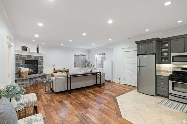 1263 Chapman Court Alpine, UT 84004 - Photo 83 of 83 Kitchen with crown molding, open floor plan, stainless steel appliances, light wood-type flooring, and glass fronted cabinets