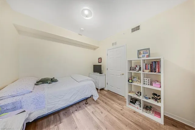 a bedroom with a bed and a wooden floor