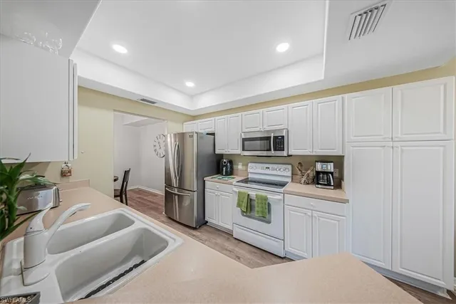 a kitchen with stainless steel appliances granite countertop a refrigerator and a sink
