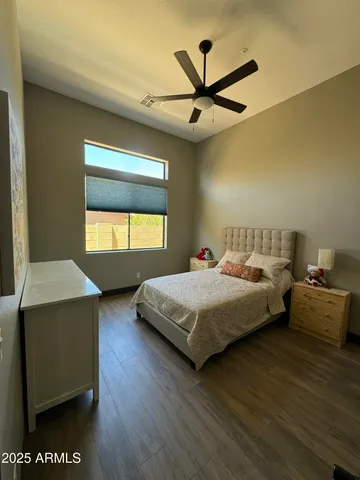 a spacious bedroom with a bed and wooden floor