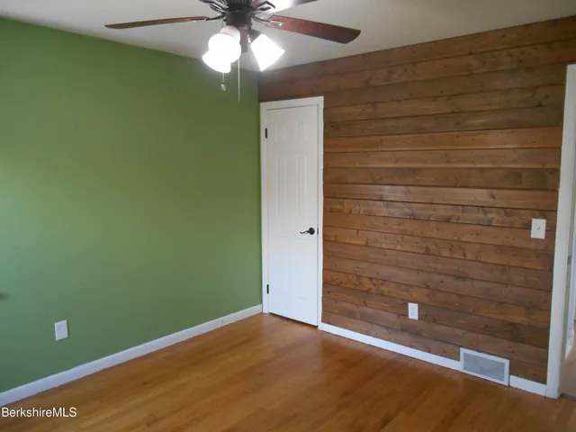 a view of empty room with window and ceiling fan